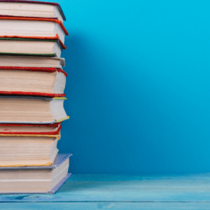 Stack of textbooks against a blue background