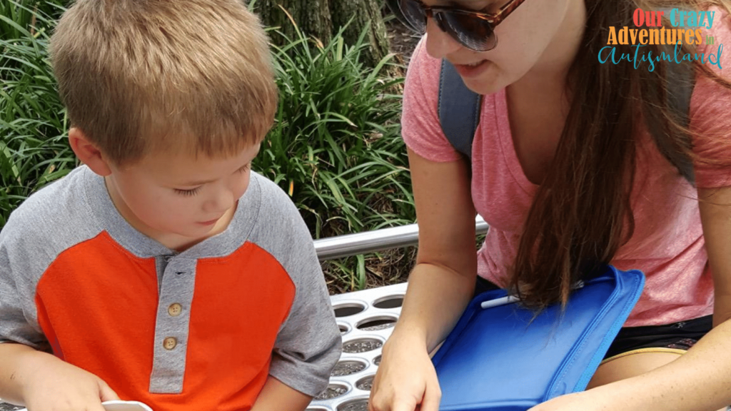 mom showing young boy something in a blue binder