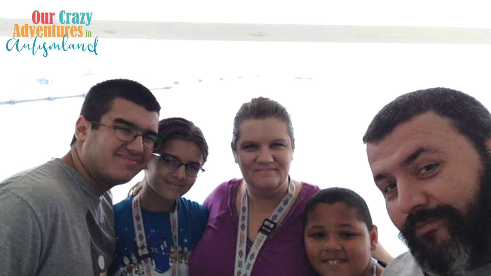 Mom, Dad, 2 teens, and a preteen smiling at a picture